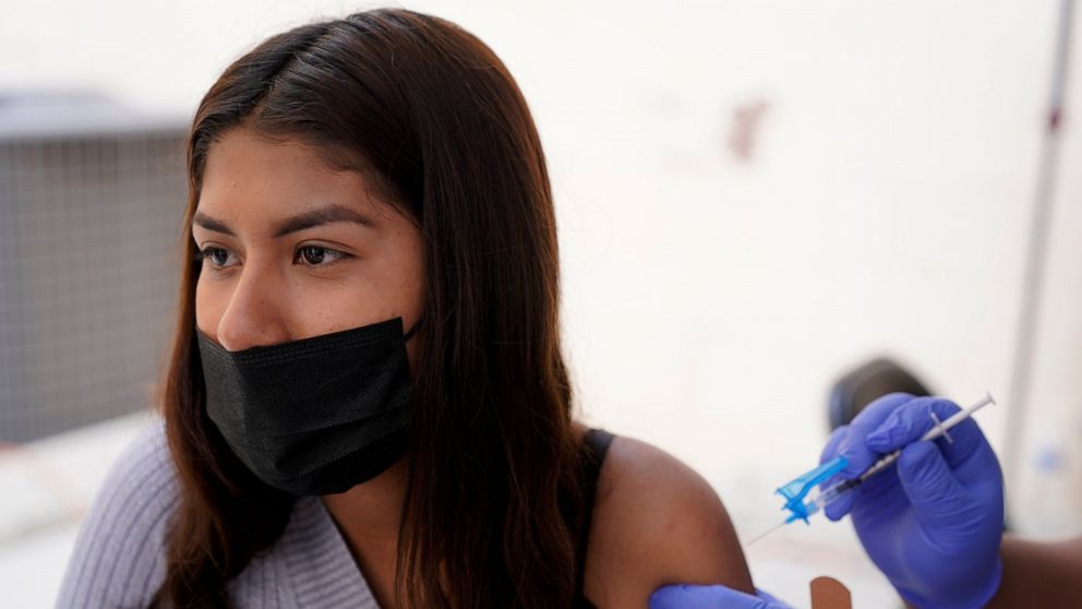 A young woman from Tijuana, Mexico, receives a vaccination shot against the coronavirus outside of the Mexican Consulate building, Thursday, Nov. 18, 2021, in San Diego. Scores of Mexican adolescents were bused to California on Thursday to get vaccin