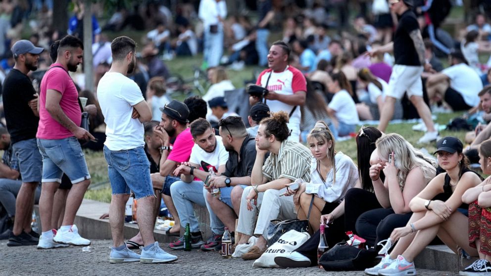 People are seen at the "Monbijoupark" (Monbijou Park) during a warm summer evening in Berlin, Germany, Friday, June 11, 2021. (AP Photo/Michael Sohn)