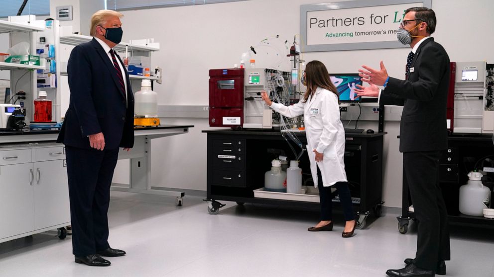 Fujifilm Diosynth Biotechnologies CEO Martin Meeson, right, speaks as President Donald Trump wears a face mask as he participates in a tour of Bioprocess Innovation Center at Fujifilm Diosynth Biotechnologies, Monday, July 27, 2020, in Morrisville, N