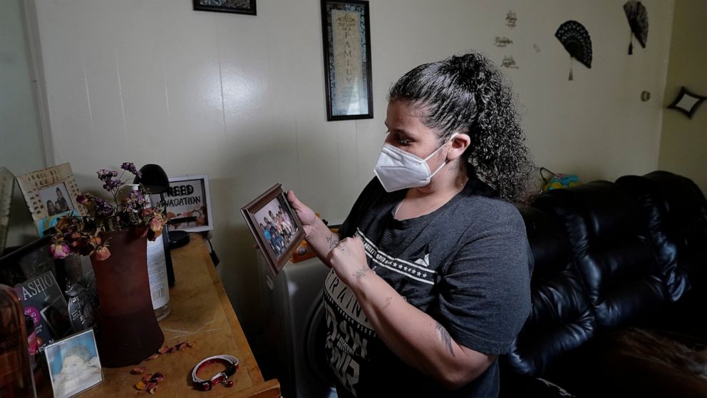 Roxanne Schaefer holds a photograph in the living room of her apartment, in West Warwick, R.I., Tuesday, July 27, 2021. Schaefer, who is months behind on rent, is bracing for the end to a CDC federal moratorium Saturday, July 31, 2021, a move that co