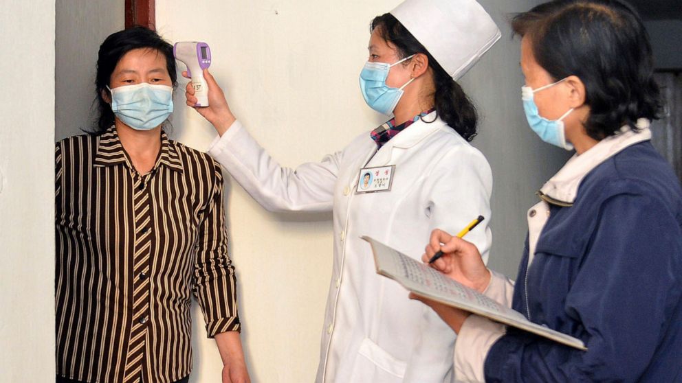 FILE - In this photo provided by the North Korean government, a doctor checks a resident's temperature to curb the spread of coronavirus infection, in Pyongyang, North Korea on May 17, 2022. North Korea said Friday, May 20, that nearly 10% of its 26 