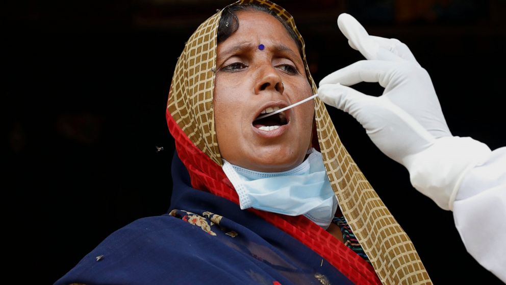 A health worker takes a swab sample of a woman to test for COVID-19 in Kusehta village north of Prayagraj, India, Saturday, May 29, 2021. (AP Photo/Rajesh Kumar Singh)