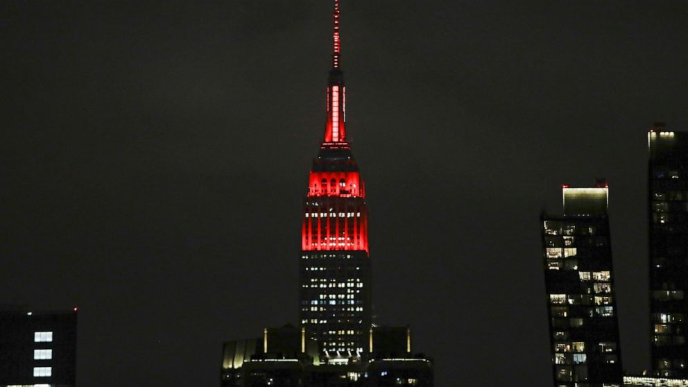 The Empire State building is lit in red and white lights to honor emergency medical workers Tuesday, March 31, 2020, in New York. The new coronavirus causes mild or moderate symptoms for most people, but for some, especially older adults and people w