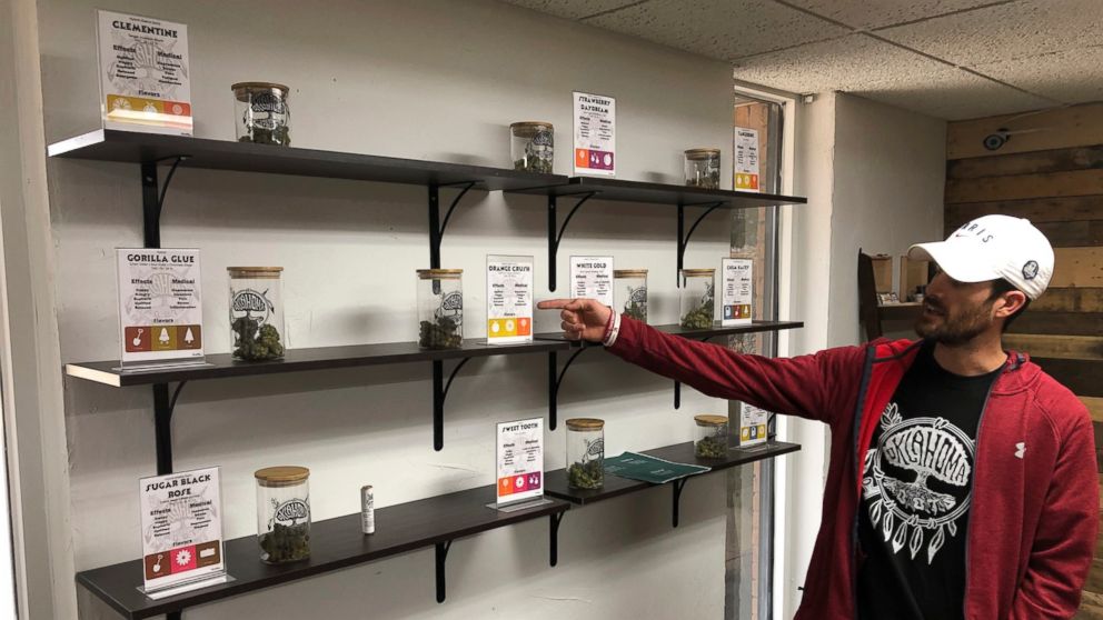 In this Nov. 30, 2018 photo, medical marijuana dispensary owner Chance Gilbert displays some of the marijuana he's grown at the Oklahoma Roots dispensary in the bedroom community of Shawnee, about 40 miles east of Oklahoma City. The roll out of state