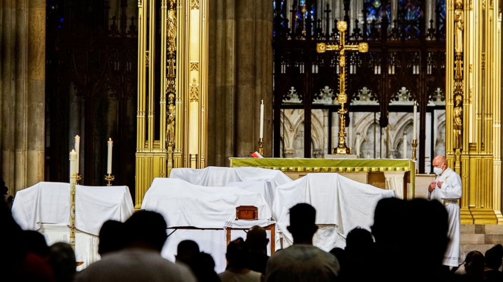 FILE - In this Saturday, July 11, 2020 file photo, mourners attend the blessing of ashes of Mexicans who died from COVID-19 during a payer a service at St. Patrick's Cathedral in New York, before they were repatriated to Mexico. The Roman Catholic Ar