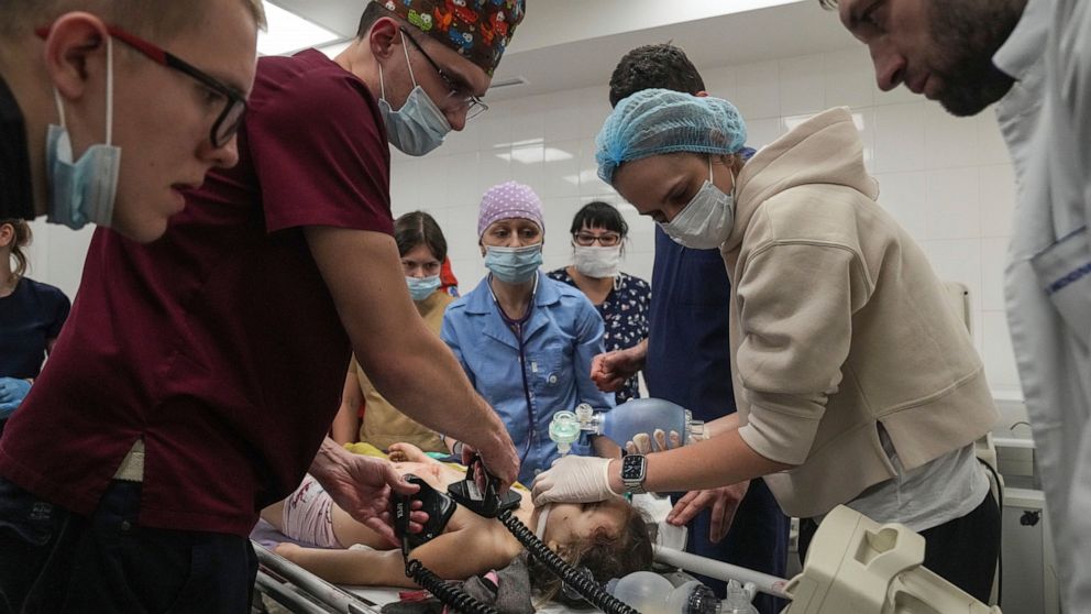 FILE - Nurse Dmytro Gavro, left, with his colleagues perform CPR on a girl fatally injured during the shelling of a residential area, in the city hospital of Mariupol, eastern Ukraine, Sunday, Feb. 27, 2022. A team of doctors and nurses who fled Mari