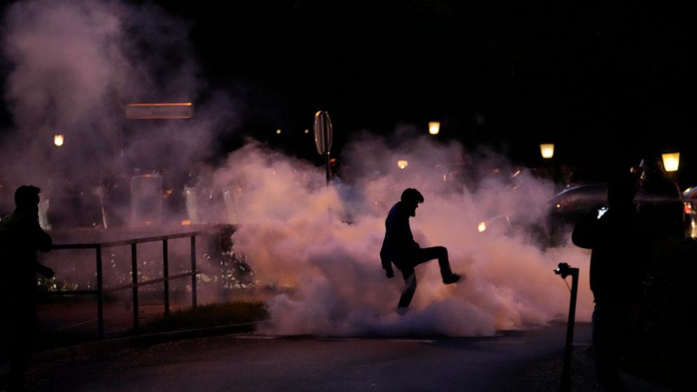 A demonstrator stomps on a smoke canister during a protest against vaccinations and coronavirus measures in Ljubljana, Slovenia, Tuesday, Oct. 5, 2021. EU leaders are meeting Tuesday evening in nearby Kranj, Slovenia, to discuss increasingly tense re
