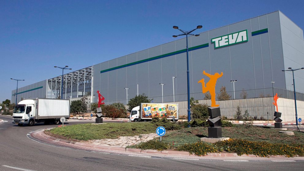 FILE - Trucks drive in front of Teva Pharmaceutical Logistic Center in the town of Shoam, Israel, on Oct. 16, 2013. Opioid makers Allergan and Teva have agreed to pay $54 million in cash and overdose reversal drugs to settle a federal lawsuit brought
