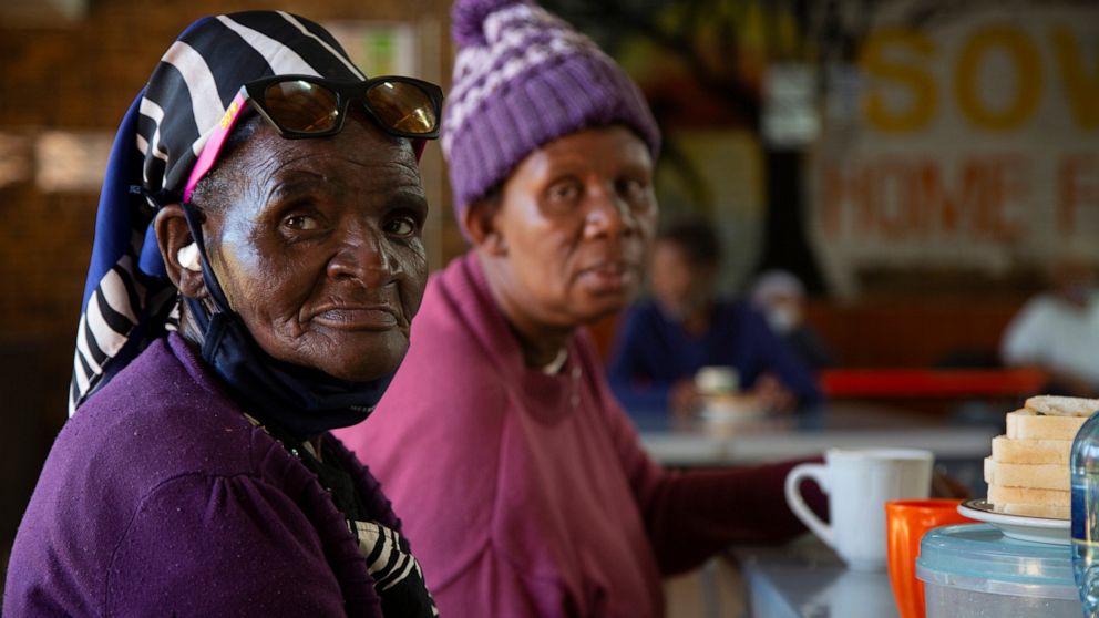 People living at the Soweto Home For The Aged practice social distancing during breakfast in Johannesburg, Tuesday, Dec. 14, 2021. An analysis of data from South Africa shows the omicron variant appears to cause less severe disease than previous vers