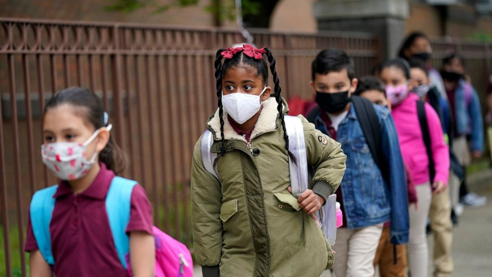 FILE - Students line up to enter Christa McAuliffe School in Jersey City, N.J., Thursday, April 29, 2021. Gov. Phil Murphy is set to announce Friday, Aug. 6 that New Jersey students from kindergarten to 12th grade and staff members will be required t