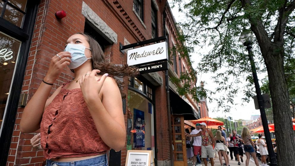 A pedestrian, left, wears a mask out of concern for the coronavirus while walking along Boston's fashionable Newbury Street, Sunday, Aug. 8, 2021. (AP Photo/Steven Senne)