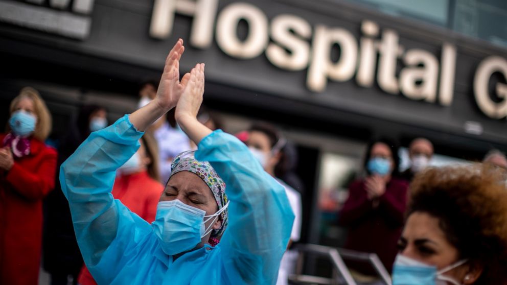 Healthcare workers protest against plans by Madrid's authorities to force staff to transfer to other hospitals at La Paz hospital in Madrid, Spain, Friday, Jan. 22, 2021. Virus infections have been increasing steeply following Christmas and New Year,