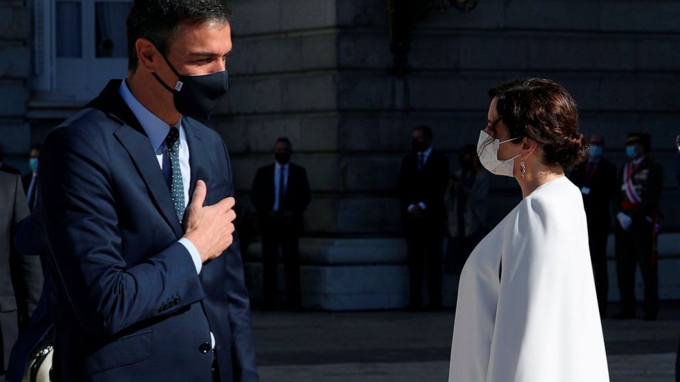 FILE - In this Monday, Oct. 12, 2020 file photo, Spain's Prime Minister Pedro Sanchez, left, welcomes Madrid's regional president Isabel Diaz Ayuso, center, and Madrid's mayor Jose Luis Martinez Almeida during an event to commemorate the 'Dia de la H