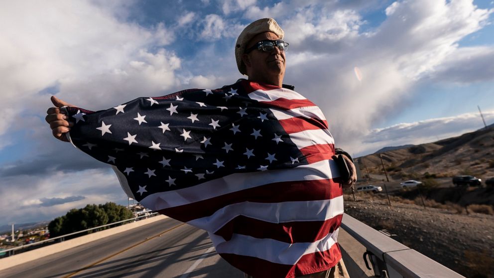 FILE - John Hiickman cheers on a convoy of truckers heading toward Washington to protest COVID-19 mandates, Feb. 23, 2022, in Needles, Calif. Omicron is fading away, and so are Americans’ worries about COVID-19. Fewer Americans now say they’re concer