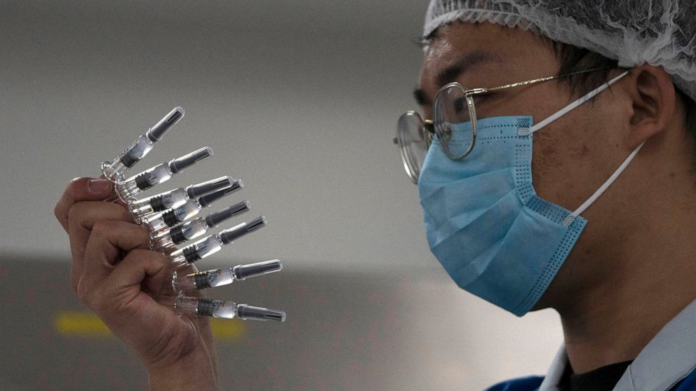 In this Sept. 24, 2020, file photo, an employee manually inspects syringes of the SARS CoV-2 Vaccine for COVID-19 produced by Sinovac at its factory in Beijing. China is rapidly increasing the number of people receiving its experimental coronavirus v