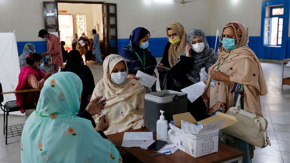 A teacher receives the first shot of the Sinovac coronavirus vaccine from a paramedic while in a vaccination center at a school in Lahore, Pakistan, Friday, May 28, 2021. (AP Photo/K.M. Chaudary)