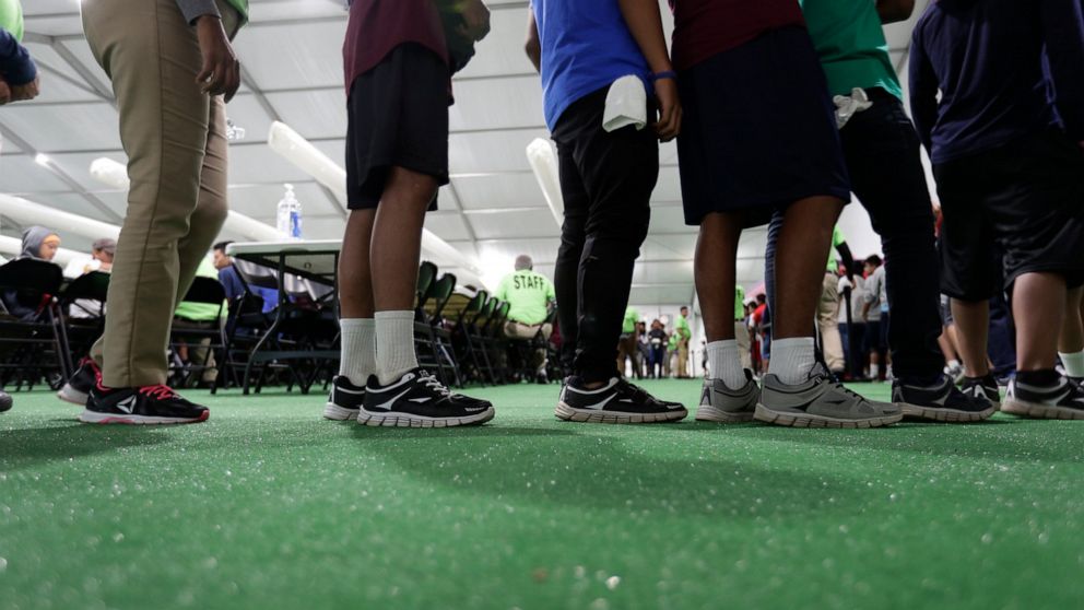 FILE - In this July 9, 2019, file photo, immigrants line up in the dinning hall at the U.S. government's newest holding center for migrant children in Carrizo Springs, Texas. The U.S. government is taking new steps to ensure access to abortion servic