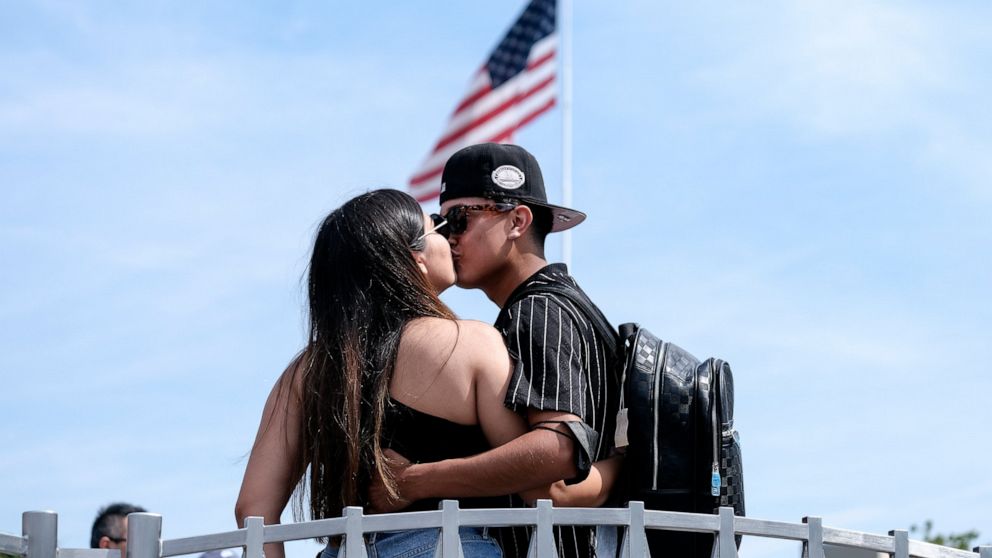 Silvia Guillen, 19, and her boyfriend Joseph Alvarez, 22, both from El Paso, Texas, share a kiss at Universal Studios in Universal City, Calif., Tuesday, June 15, 2021. On Tuesday, California lifted most of its COVID-19 restrictions and ushered in wh