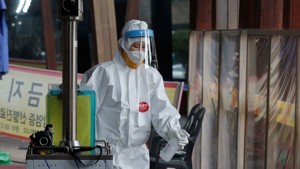 A medical worker wearing a protective suit sprays disinfectant as a precaution against the coronavirus at a coronavirus testing site in Seoul, South Korea, Thursday, Feb. 25, 2021. (AP Photo/Lee Jin-man)