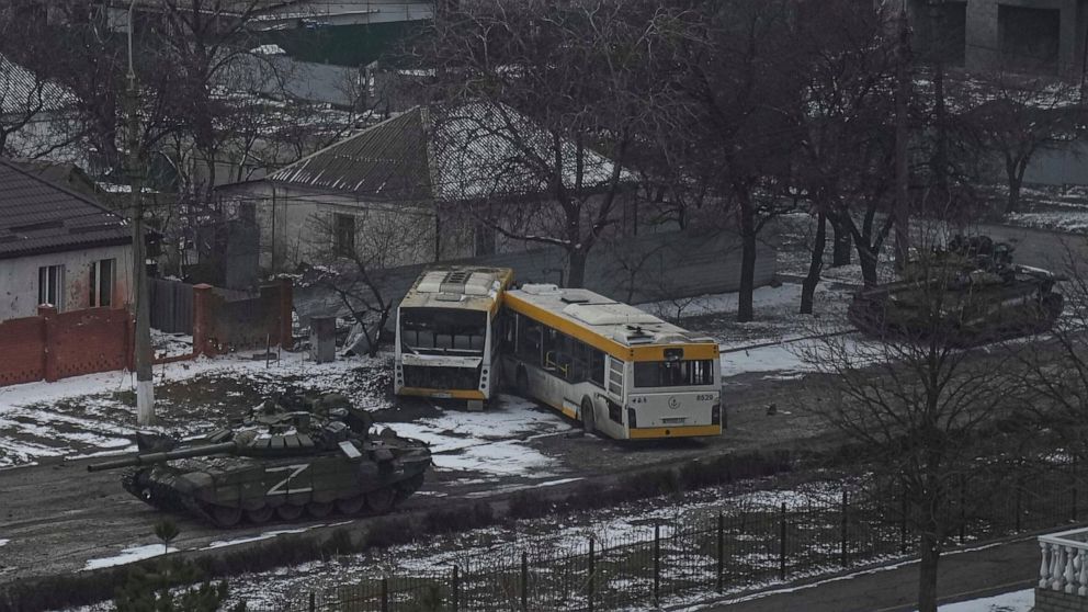 FILE - Russian's army tanks move down a street on the outskirts of Mariupol, Ukraine, Friday, March 11, 2022. With its aspirations for a quick victory dashed by a stiff Ukrainian resistance, Russia has increasingly focused on grinding down Ukraine’s 