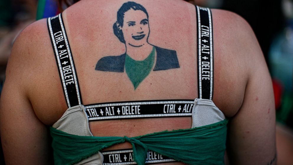 An abortion activist with a tattoo of Argentina's revered late first lady Eva Peron on her back, participates in a demonstration for the decriminalization of abortion, outside Congress as lawmakers debate a bill on its legalization, in Buenos Aires, 