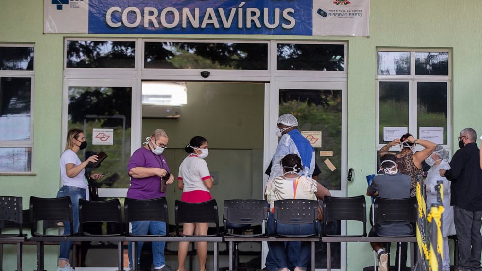 People with COVID-19 symptoms wait to be assisted outside a hospital that is at full capacity in Ribeirao Preto, Sao Paulo state, Brazil, Friday, May 28, 2021. The city imposed strict shutdown measures this week to stop the spread of the virus, halti