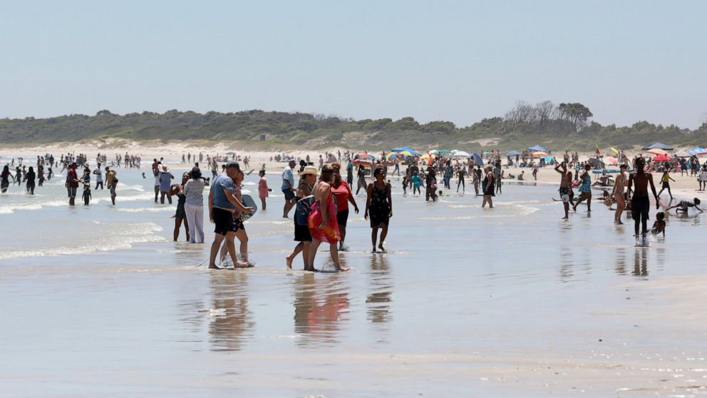 Holdiaymakers enjoy a day at Strand Beach near Cape Town, South Africa, Tuesday, Dec. 21, 2021. South Africa's drop in new COVID-19 cases in recent days may signal the country's dramatic omicron-driven surge has passed its peak, medical experts say. 