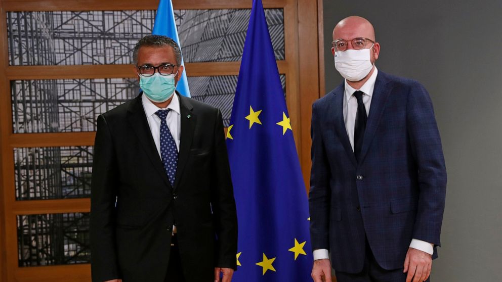 European Council President Charles Michel, right, and Director General of the World Health Organization Tedros Adhanom Ghebreyesus pose for photographers prior to their meeting at the European Council headquarters in Brussels, Tuesday, Dec. 15, 2020.