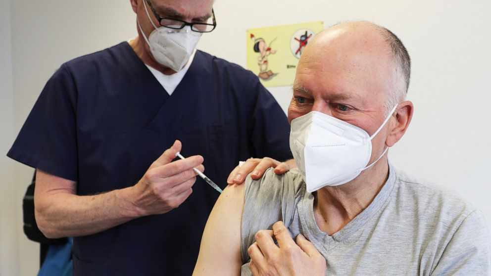 Manfred Haas, right, receives the AstraZeneca vaccine against the COVID-19 disease from his family doctor Oliver Funken in Rheinbach, Germany, Tuesday, April 6, 2021. In German federal state North Rhine-Westphalia, Corona vaccinations have started in
