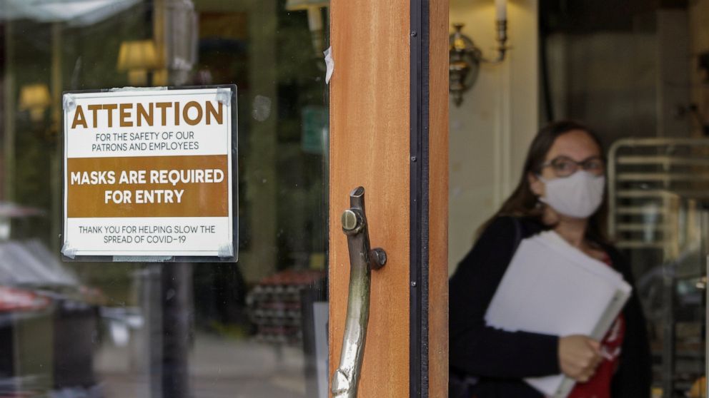 FILE - In this May 21, 2021 file photo, a sign reminds customers to wear their masks at a bakery in Lake Oswego, Ore. Oregon Gov. Kate Brown on Tuesday, Aug. 10, 2021 announced a statewide indoor mask requirement due to the spike in COVID-19 hospital