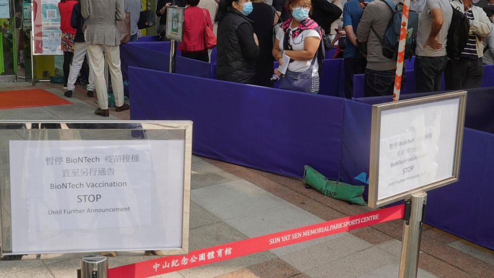 People queue up outside a vaccination center for BioNTech in Hong Kong Wednesday, March 24, 2021. Hong Kong suspended vaccinations using Pfizer shots - known as BioNTech shots in the city - on Wednesday after they were informed by its distributor Fos