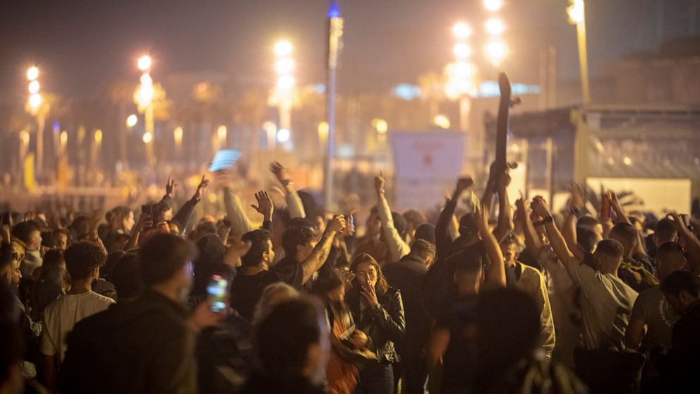 People crowded and dance on the beach in Barcelona, Spain, Sunday, May 9, 2021. Barcelona residents were euphoric as the clock stroke midnight, ending a six-month-long national state of emergency and consequently, the local curfew. Spain is relaxing