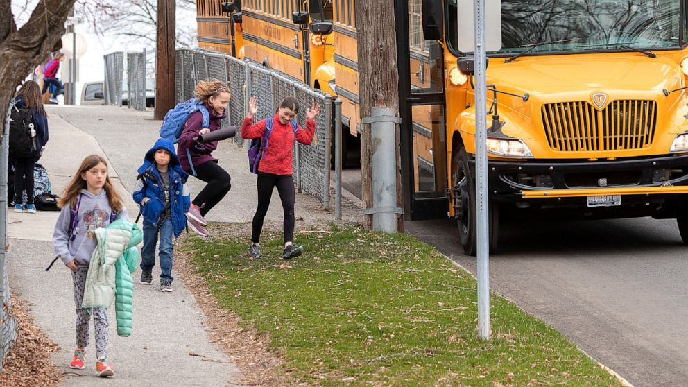 FILE - In this March 13, 2020 file photo, children head home after the last day of school before spring break, and eventual closure due to the coronaviurs utbreak, outside Russell Elementary School in Moscow, Idaho. With schools closed and teachers u