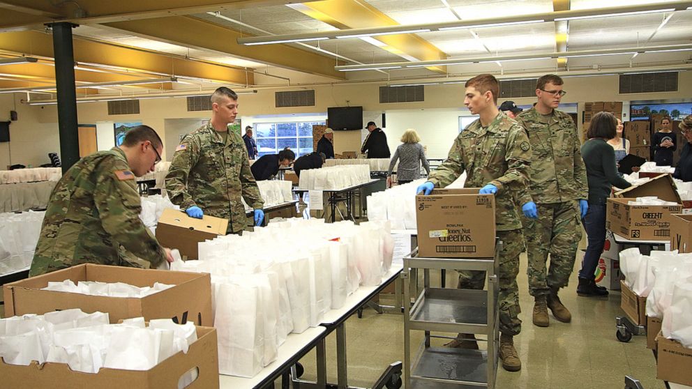 Members of the West Virginia National Guard and many volunteers assist with the preparation and distribution of around 2000 school lunches in the cafeteria at Greenbrier East High School in Fairlea, WV., Monday, March 23, 2020. The Greater Greenbrier