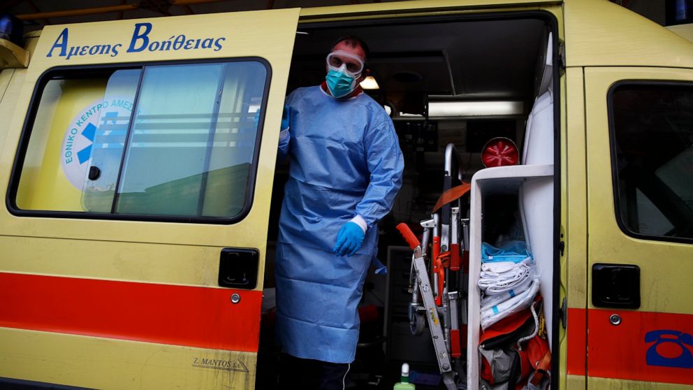 A paramedic wearing a suit to protect against coronavirus, closes the door of an ambulance at Evangelismos hospital in Athens, Thursday, Nov. 12, 2020. Greece has imposed a nationwide nightly curfew as the number of COVID-19 cases in the country cont