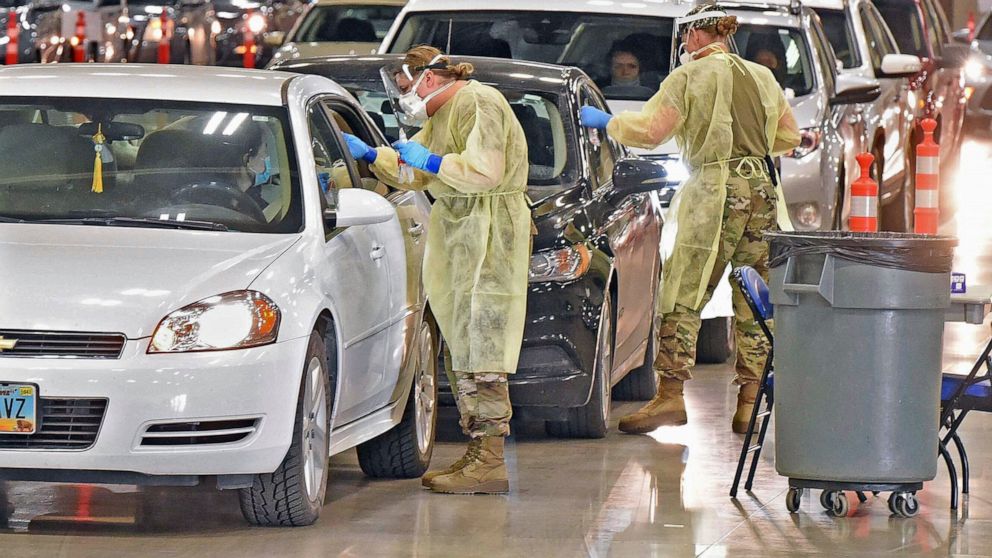 FILE - North Dakota National Guard members administer COVID-19 tests on Nov. 17, 2020, inside the Bismarck Events Center in Bismarck, N.D. The North Dakota Health Department stored thousands of COVID-19 vaccine doses at incorrect temperatures or with