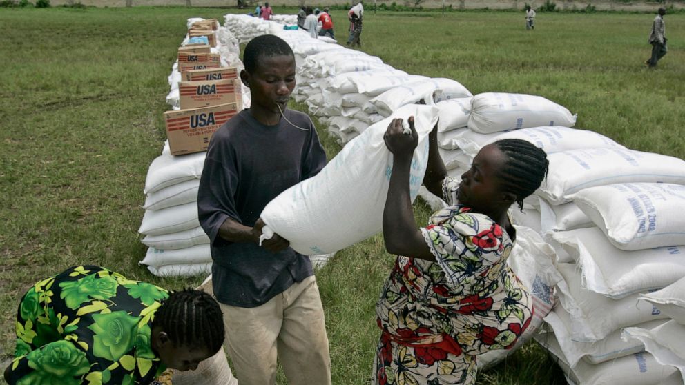 In this Nov. 14, 2008, file photo, a woman receives a bag of maize meal from the World Food Program in the town of Rutshuru, eastern Congo. The World Food Program chief warned Thursday, Sept. 17, 2020, that millions of people are closer to starvation
