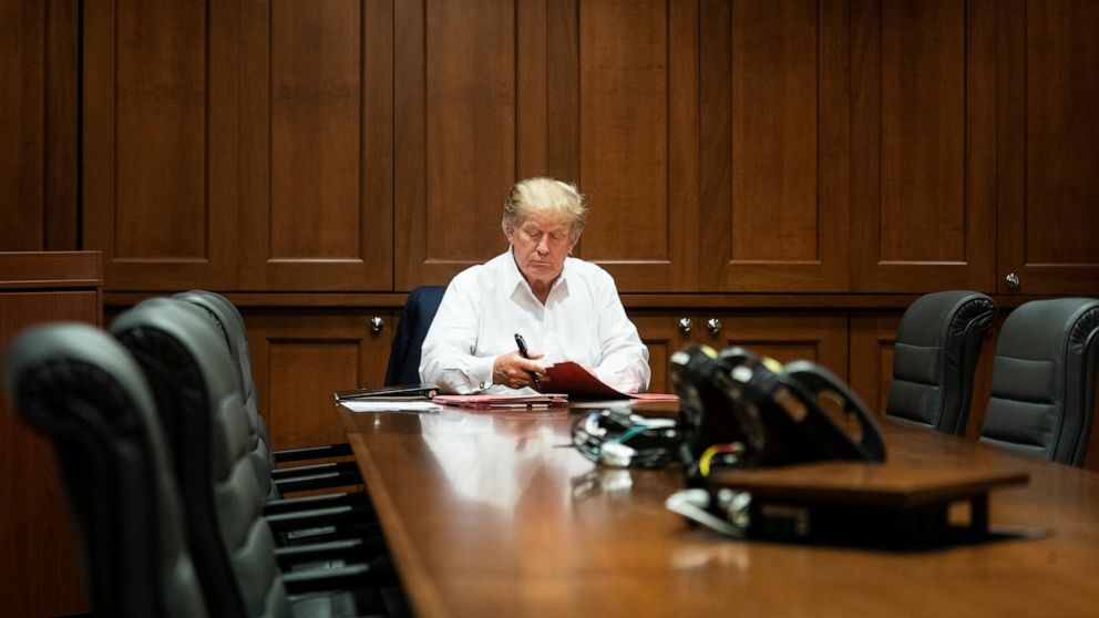 In this image released by the White House, President Donald Trump works in his conference room at Walter Reed National Military Medical Center in Bethesda, Md., Saturday, Oct. 3, 2020, after testing positive for COVID-19. (Joyce N. Boghosian/The Whit