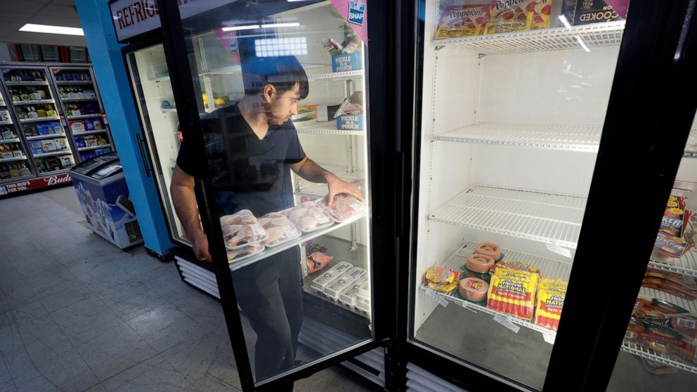 Hardik Kalra stocks meat in a cooler at a local super market, Friday, May 29, 2020, in Des Moines, Iowa. As if trips to the grocery store weren't nerve-racking enough, shoppers lately have seen the costs of meat, eggs and even potatoes soar as the co