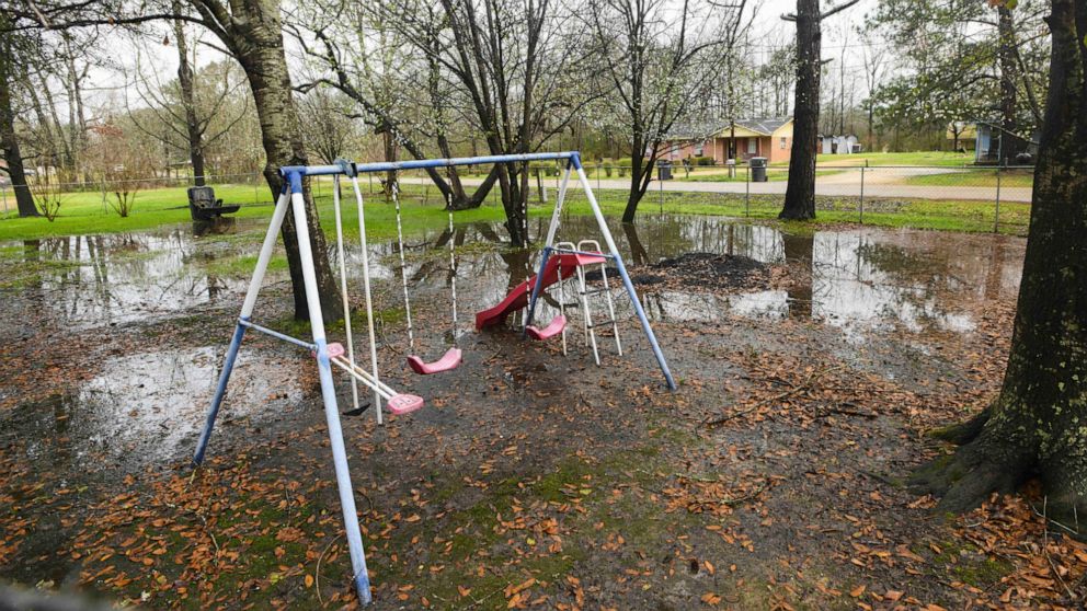 FILE - Heavy rains flood the front yard of Lowndes County resident Charlie Mae Holcombe, Feb. 21, 2019, in Hayneville, Ala. Holcombe keeps her grandchildren out of the front yard because she fears contamination from the failing wastewater sanitation 