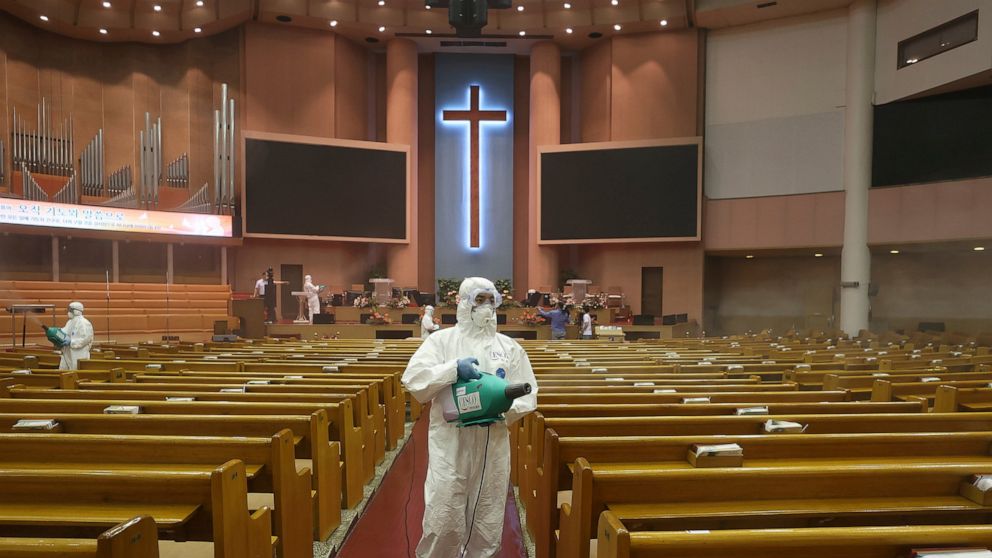 Public officials disinfect to curb the spread of the coronavirus at the Yoido Full Gospel Church in Seoul, South Korea, Tuesday, Aug. 18, 2020. South Korea will ban large public gatherings and shut down churches and nightspots in the greater capital 