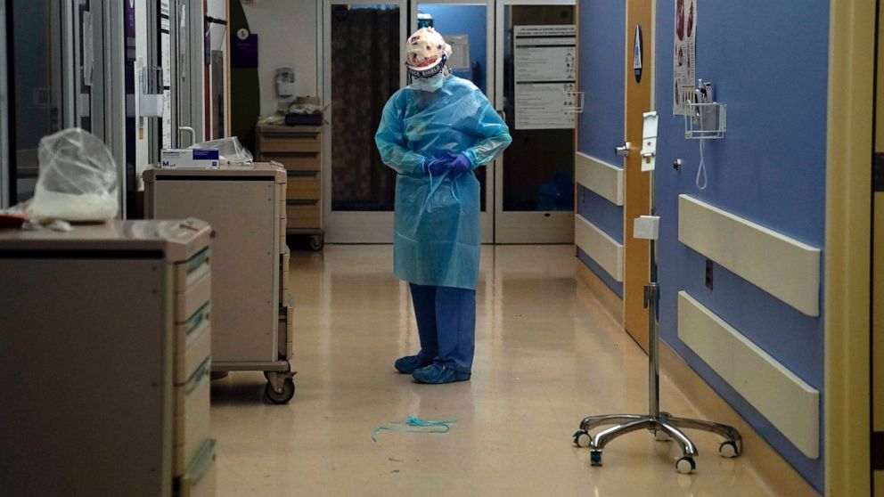 FILE - In this Jan. 7, 2021, file photo, a nurse puts on protective gear in a COVID-19 unit in California. The nation’s biggest immunization rollout in history is facing pushback from an unlikely source: health care workers who witnessed COVID-19′s d