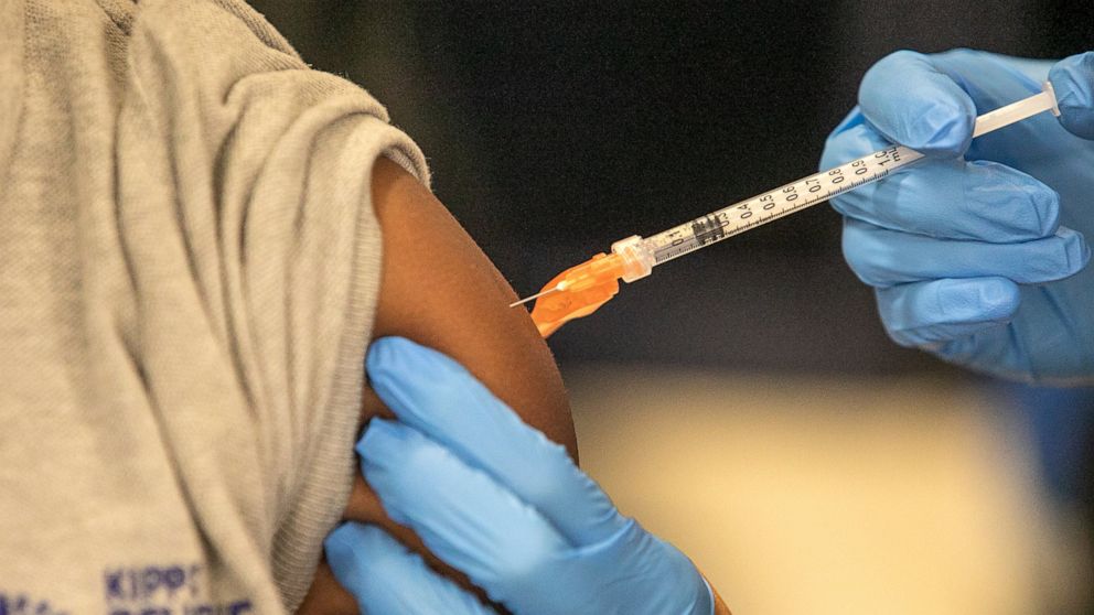 FILE - Medical personnel vaccinate students at a school in New Orleans on Jan. 25, 2022. A Centers for Disease Control and Prevention advisory committee on Thursday, Oct. 20, 2022 voted that the agency should update its recommended immunization sched