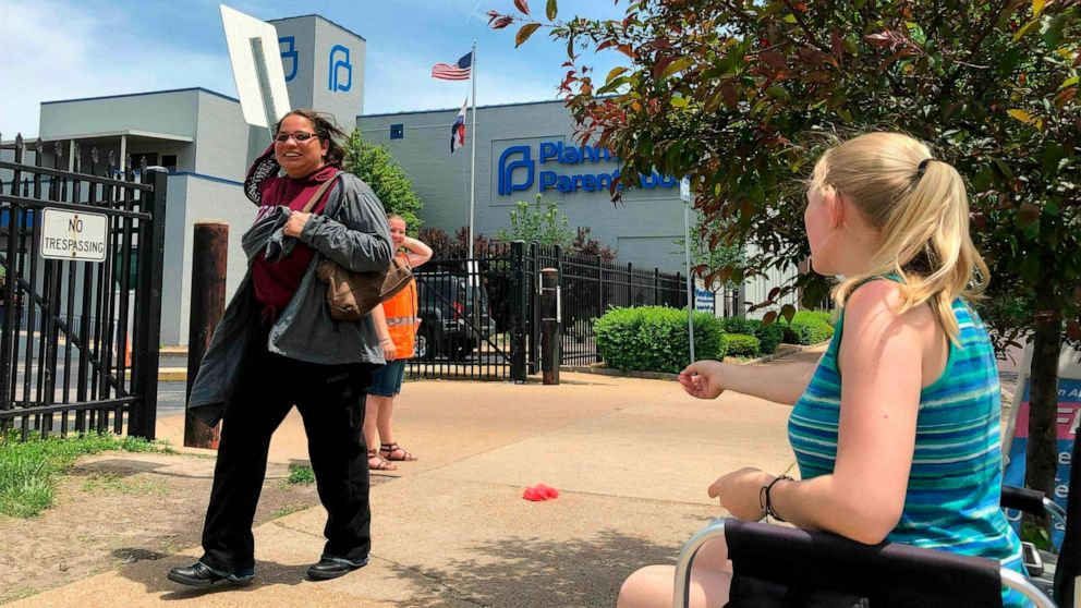 FILE - In this May 17, 2019 file photo, Teresa Pettis, right, greets a passerby outside the Planned Parenthood clinic in St. Louis. Pettis was one of a small number of abortion opponents protesting outside the clinic on the day the Missouri Legislatu