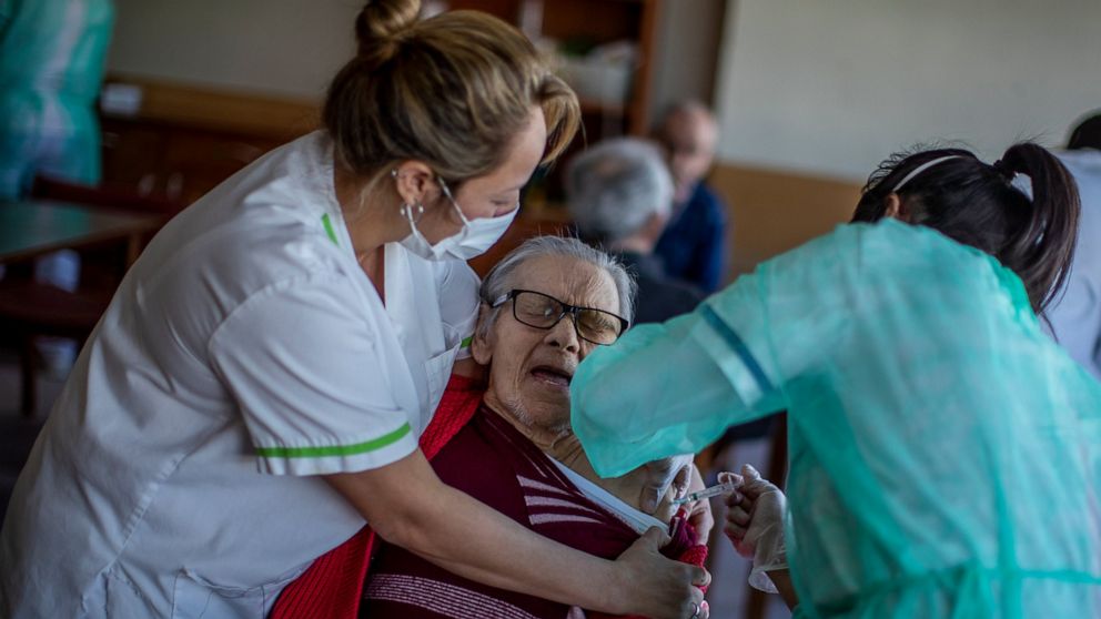 A nurse administers the Pfizer-BioNTech COVID-19 vaccine to a resident at DomusVi nursing home in Leganes, Spain, Wednesday, Jan. 13, 2021. Spain's rate of infection has shot up to 435 cases per 100,000 residents in the past two weeks, prompting new 