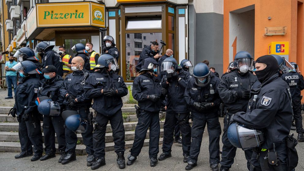 Police watch as people take part in a protest against coronavirus restrictions, in Berlin, Sunday, Aug. 29, 2021. (Christophe Gateau/dpa via AP)