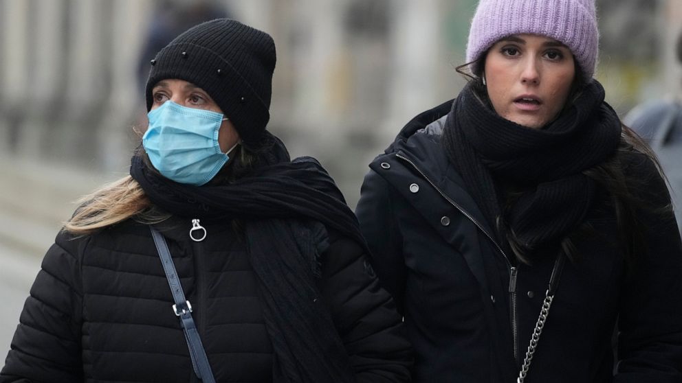 People walk on the streets of in Warsaw, Poland, on Friday Nov. 26, 2021. Poland's resistance to introducing new lockdowns and restrictions amid skyrocketing COVID-19 infections and deaths is drawing criticism from the country's medical professionals