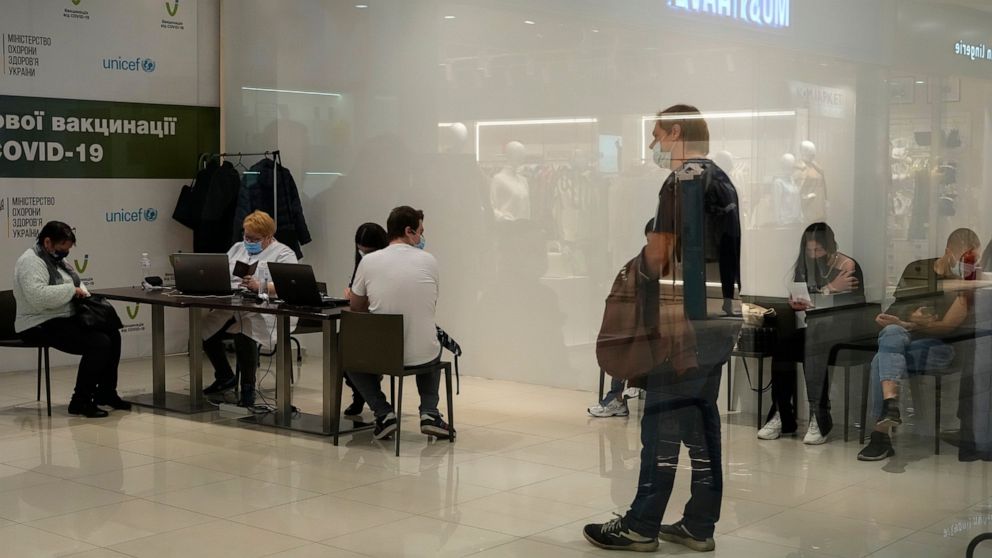 People wait for their turn in a vaccination center in a city mall in Kyiv, Ukraine, Thursday, Oct. 21, 2021. Coronavirus infections and deaths in Ukraine have surged to all-time highs amid a laggard pace of vaccination, which is one of the lowest in 