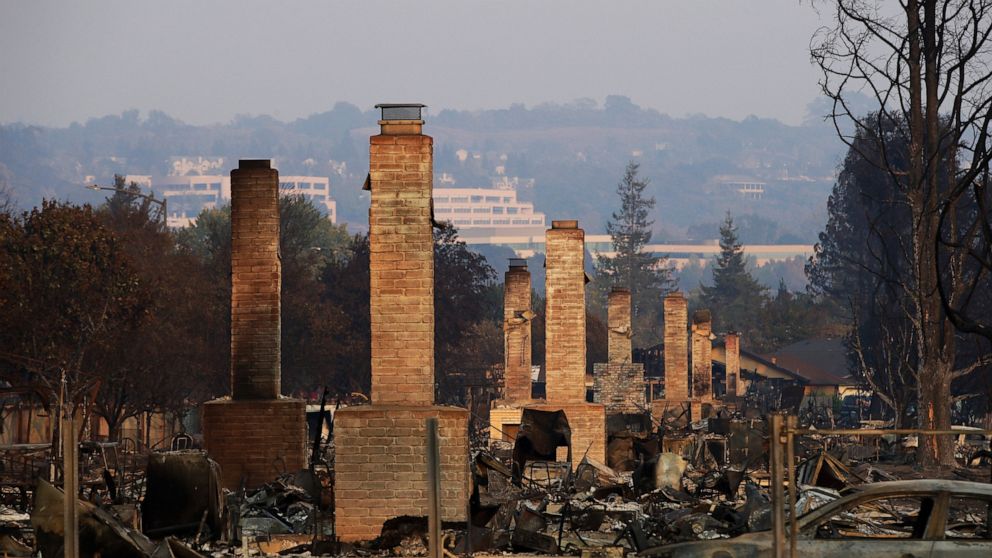 FILE - In this Oct. 13, 2017, file photo, a row of chimneys stand in a neighborhood devastated by the Tubbs fire near Santa Rosa, Calif. A trust representing more than 80,000 victims of deadly wildfires ignited by Pacific Gas and Electric's rickety e