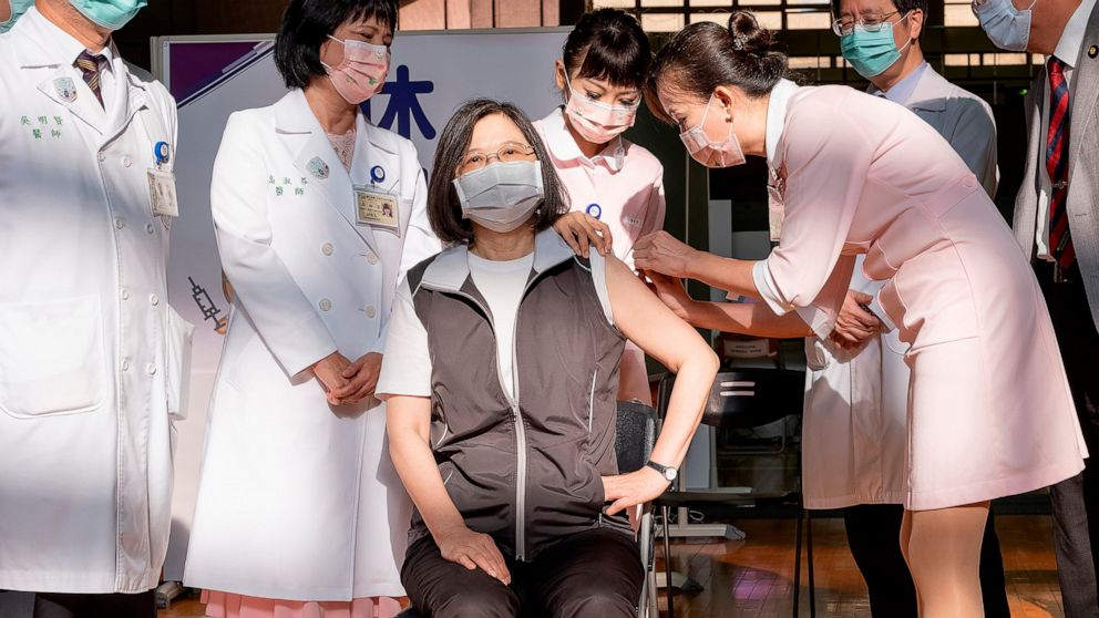 In this photo released by the Taiwan Presidential Office, Taiwanese President Tsai Ing-wen, center, receives her first shot of the island's first domestically developed coronavirus vaccine made by Medigen Vaccine Biologics Corp. at the Taiwan Univers
